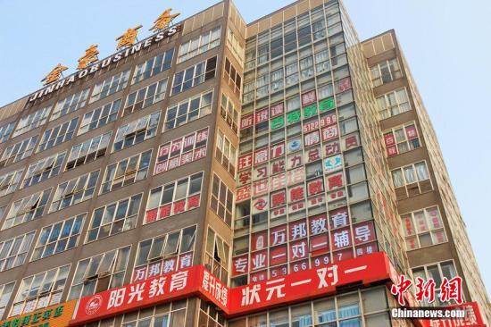 资料图：一栋写字楼的窗户上挂满了辅导班的广告。图片来源：CFP视觉中国