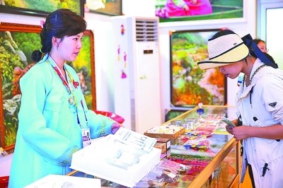 游客在朝鲜展馆购买特色产品。本报记者 郭俊锋/摄